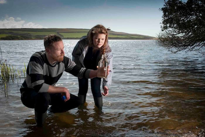 Man and girl test water quality